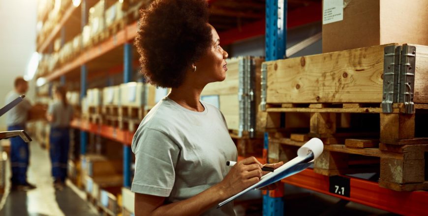 african-american-worker-writing-inventory-list-while-checking-stock-storage-room