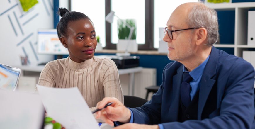 african-employee-discussing-with-senior-executive-looking-financial-charts-startup-company-conference-board-room