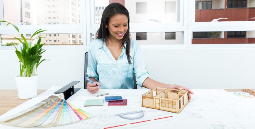 smiling-african-american-lady-chair-taking-notes-near-plan-model-house-table (1)